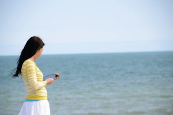 Woman In Yellow Long Sleeved Shirt And White Skirt Walking On Seashore