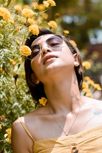 Woman in Yellow Spaghetti Strap Top Beside yellow Flowers