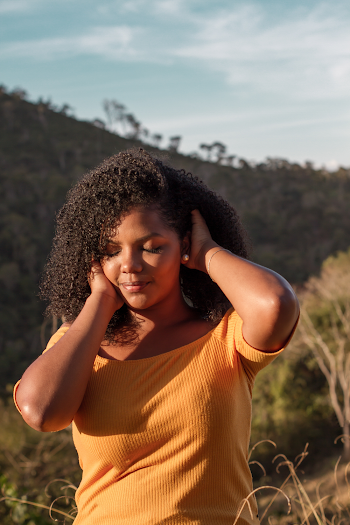 Woman in Yellow Top Holding Her Hair Outdoors