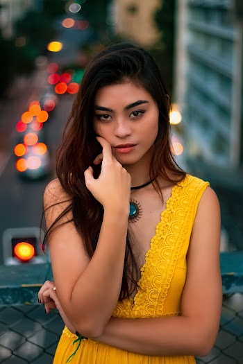 Woman in Yellow V-neck Sleeveless Dress Leaning on Fence