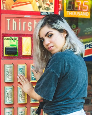 Woman Infront Of A Red Vending Machine