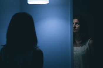 Woman Inside Blue Room Looking on White Pendant Lamp