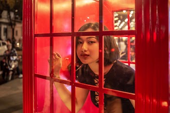 Woman Inside Red Telephone Booth