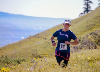 Woman Jogging in Green Grass Covered Hill Slope