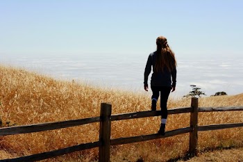 woman jump on brown fence
