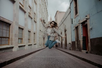 Woman Jumping Near Buildings