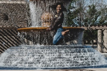 Woman Jumping Near Fountain