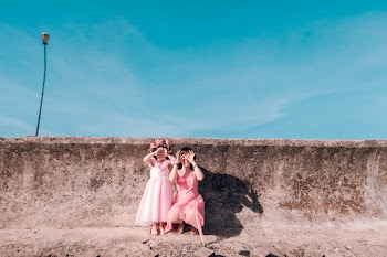 Woman Kneeling Beside Girl Near Wall
