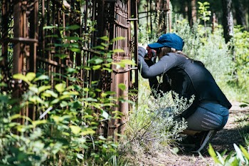 Woman Kneeling Near Brown Gate Panel