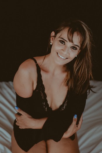 Woman Kneeling On Bed While Smiling