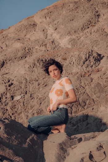 Woman Kneeling on Rock Formation