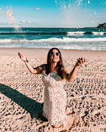 Woman Kneeling On Sand Under Blue Skies