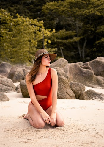 Woman Kneeling on Seashore Near Rocks
