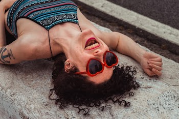 Woman Laughing Lying on Concrete Slab