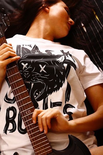 woman laying on bed holding guitar