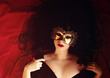 Woman Laying On Red Textile Wearing Gold Mask