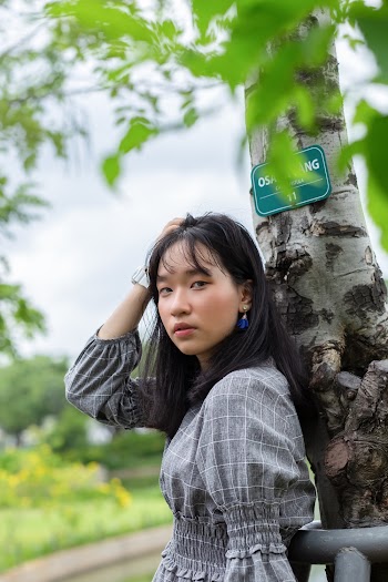 Woman Leaning Against A Tree