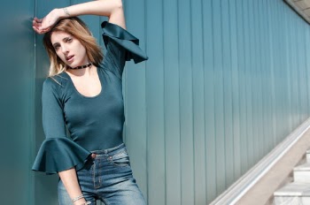 Woman Leaning Against Blue Wall