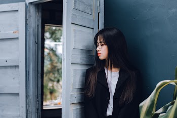 Woman Leaning Against Open Door