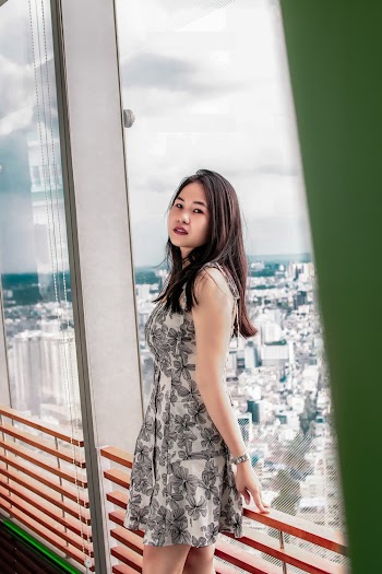 Woman Leaning Against Red Metal Railing