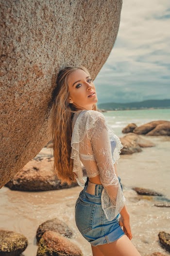 Woman Leaning Back on Rock While Looking at the Camera