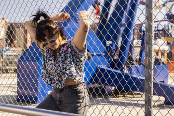 Woman Leaning Beside Metal Fence