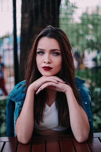 Woman Leaning Both Hands on Wooden Table