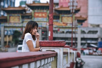 Woman Leaning Forward on Concrete Handrail during Day