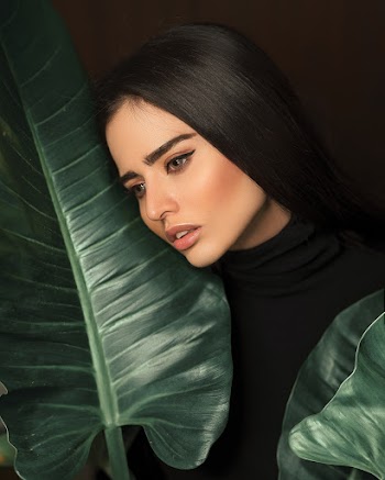 Woman Leaning Her Face on Leaf