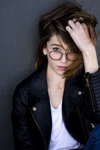 Woman Leaning in Front of Gray Wall