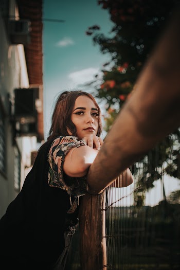 Woman Leaning On A Fence