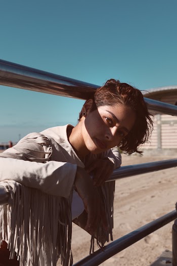 Woman Leaning On A Gray Metal Railing