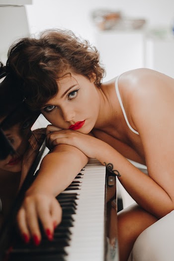 Woman Leaning on Black and White Electronic Keyboard