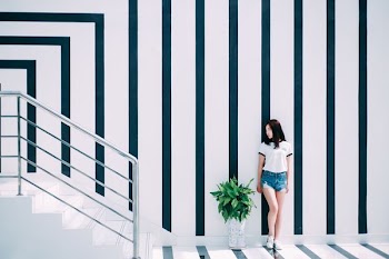 woman leaning on black and white wall