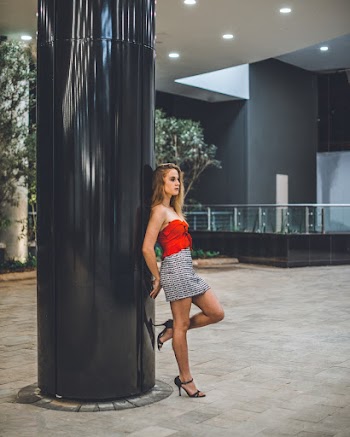 Woman Leaning On Black Post