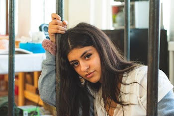 Woman Leaning on Black Rod