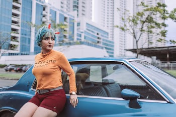 Woman Leaning on Blue Coupe