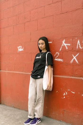 Woman Leaning on Brown Concrete Wall