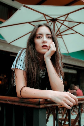 Woman Leaning on Brown Fence