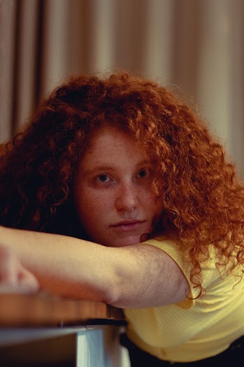 Woman Leaning On Brown Wooden Panel Board