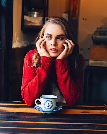 Woman Leaning on Brown Wooden Table