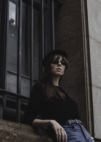 Woman Leaning on Building Wall