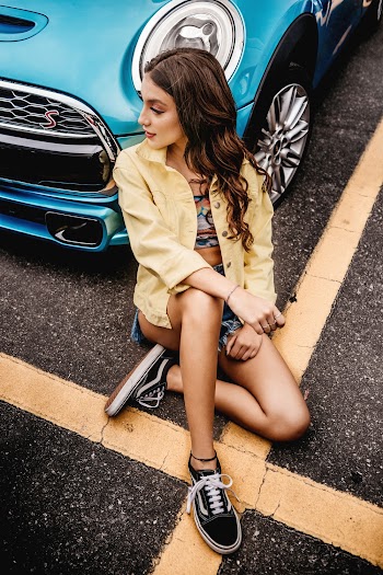 Woman Leaning on Car in Parking Area