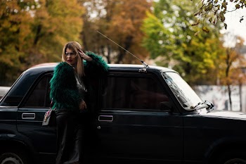 Woman Leaning on Car Surrounded Trees