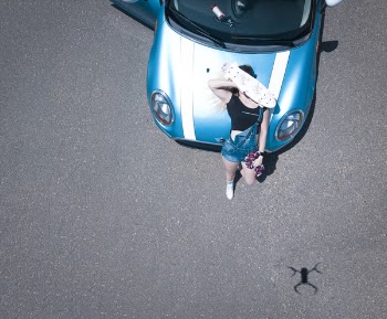Woman Leaning on Car While Holding Penny Board