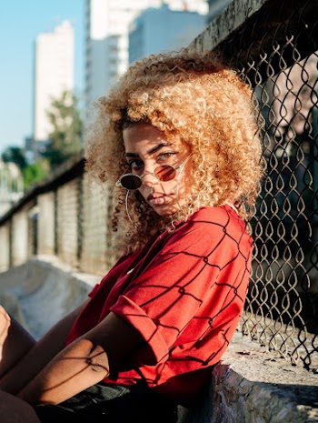 Woman Leaning On Chain Link Fence