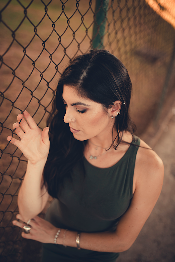 Woman Leaning on Chain Link Fence
