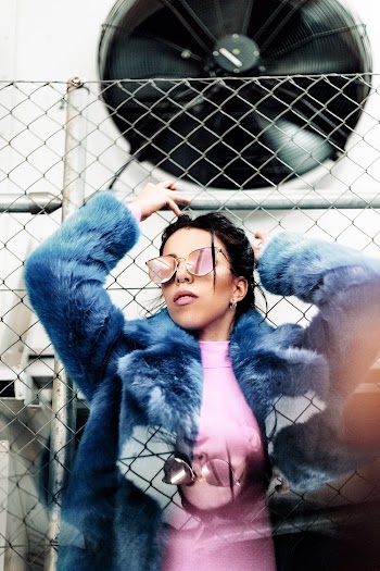 Woman Leaning On Chain-link Fence