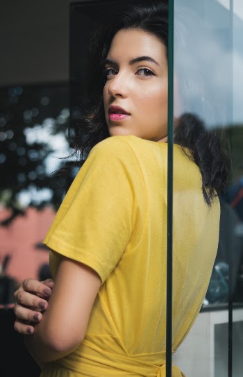Woman Leaning on Clear Glass Panel