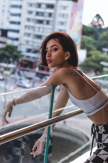 Woman Leaning on Clear Glass Railing